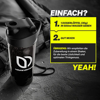 Eine schwarze Shakerflasche mit "natural elements"-Logo steht auf einer dunklen Fläche. Eine Anleitung auf Deutsch erklärt, wie man 30g Pulver mit 500ml Wasser im Shaker mischt.
